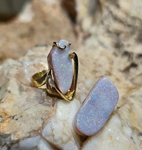 Ring with opal stone on a rock with another opal not in a ring